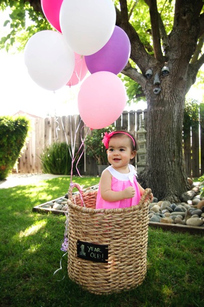Baby girl in basket with balloons